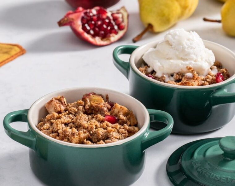 Warm apple crumble desserts with vanilla ice cream, pomegranate, and pears.