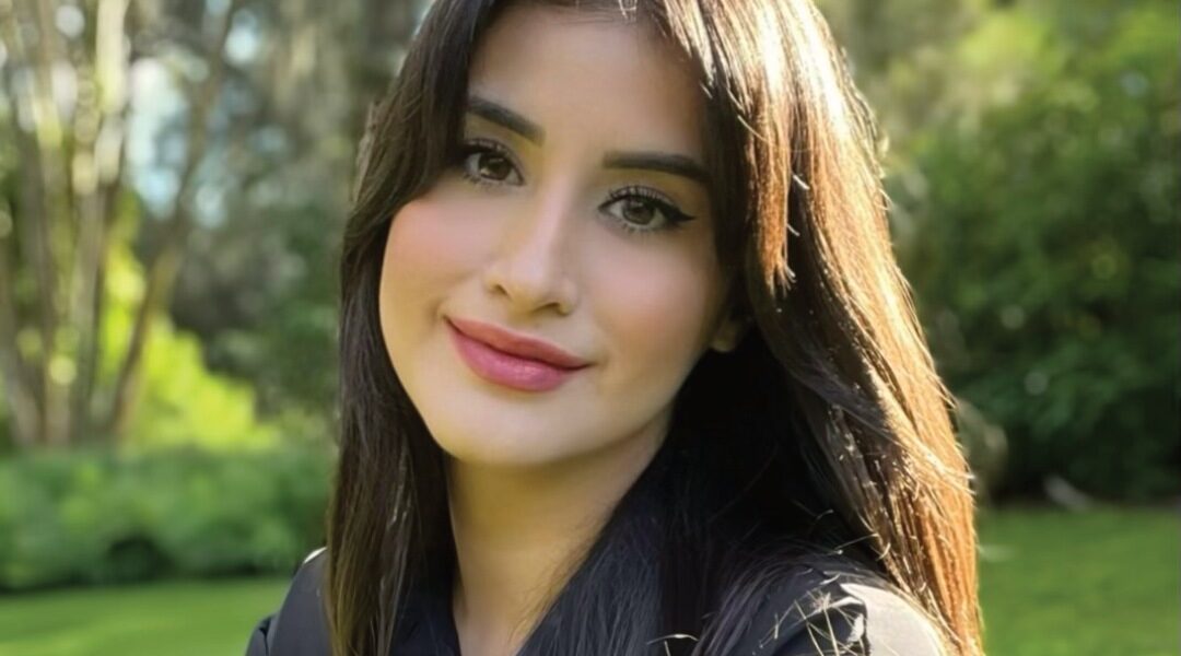Olivia Sanchez, founder of Sudz Cauldron, outdoors against a green garden background