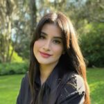 Olivia Sanchez, founder of Sudz Cauldron, outdoors against a green garden background