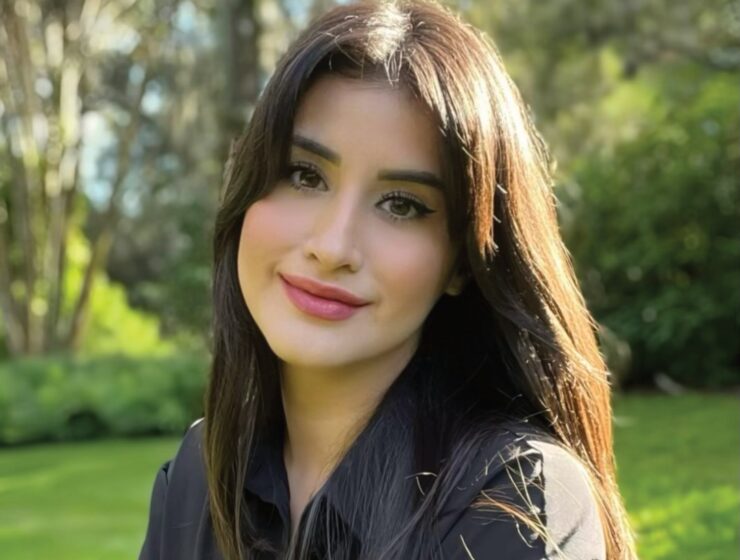 Olivia Sanchez, founder of Sudz Cauldron, outdoors against a green garden background