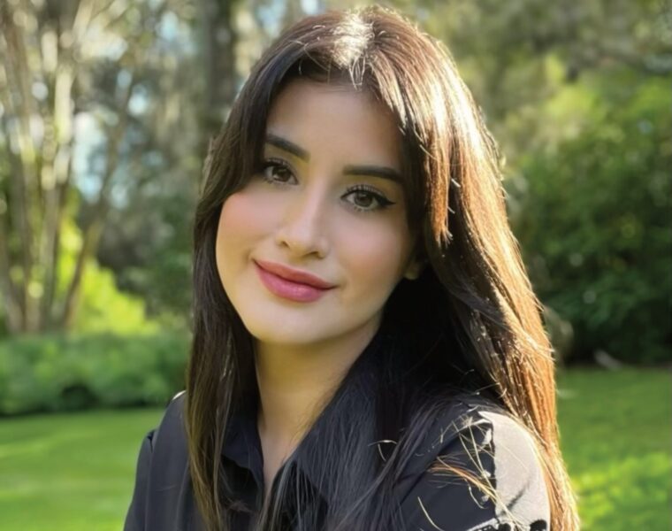 Olivia Sanchez, founder of Sudz Cauldron, outdoors against a green garden background