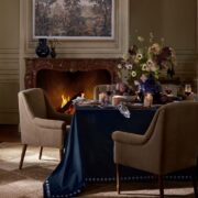 Pottery Barn x Kravet Fall collection dining room with a floral table and fireplace
