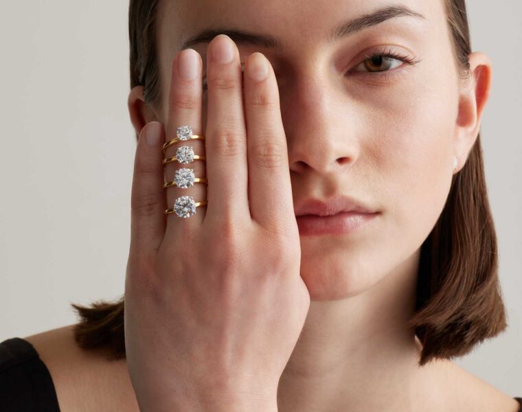 A woman displaying solitaire diamond rings