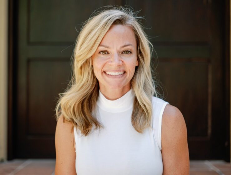 Sadie Gardere smiling in a white sleeveless top outside a doorway